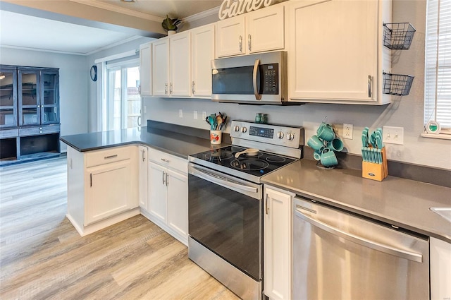 kitchen featuring a peninsula, white cabinets, stainless steel appliances, and crown molding