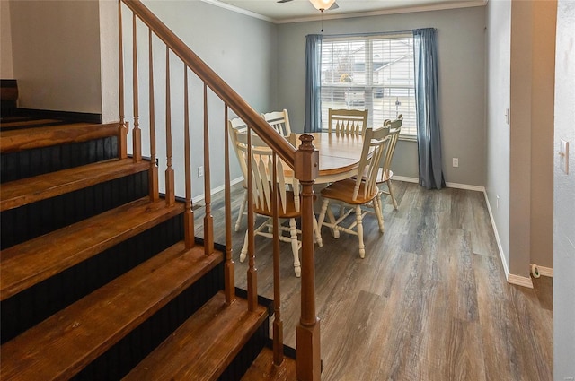 dining space with wood finished floors, a ceiling fan, baseboards, stairs, and ornamental molding