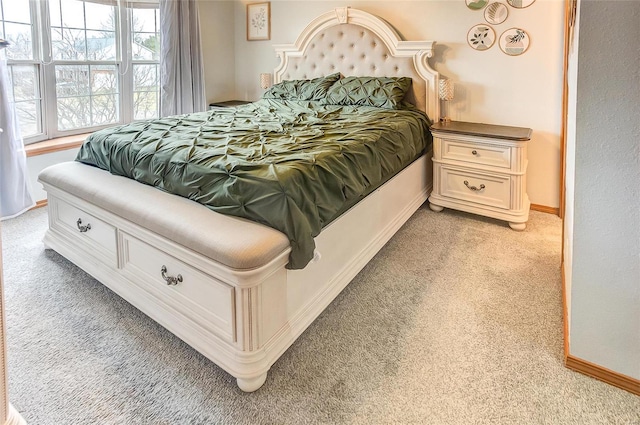 bedroom featuring light carpet and baseboards