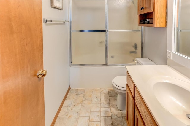 bathroom with enclosed tub / shower combo, vanity, and toilet