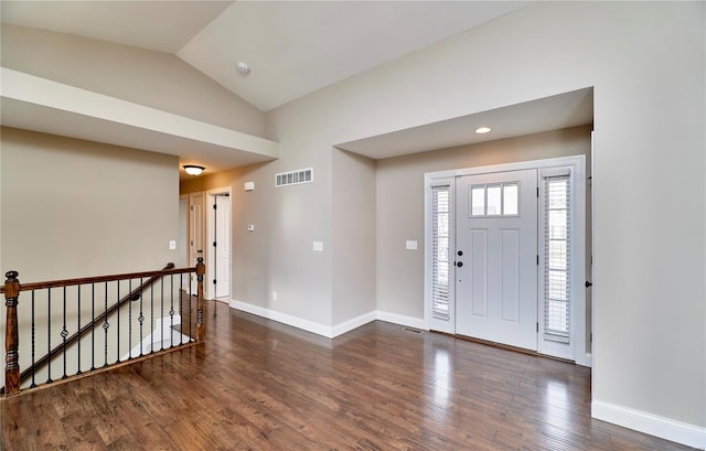 foyer entrance featuring visible vents, vaulted ceiling, baseboards, and wood finished floors