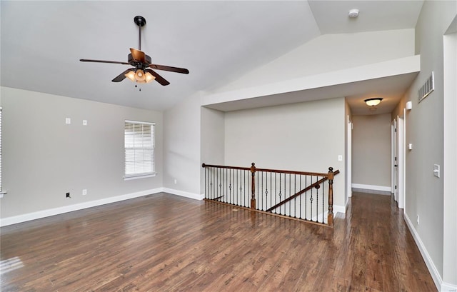 spare room featuring visible vents, ceiling fan, vaulted ceiling, wood finished floors, and baseboards