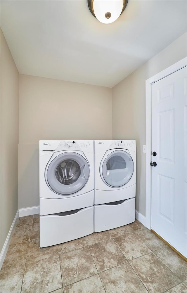 laundry area with baseboards, laundry area, and washer and dryer