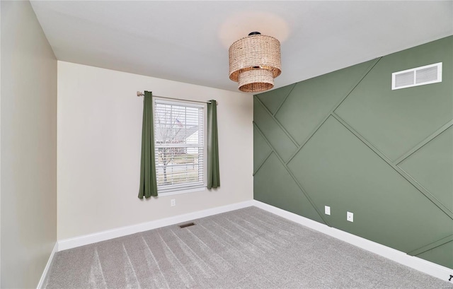 carpeted spare room with baseboards and visible vents