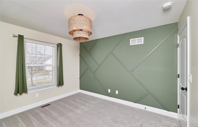 carpeted spare room featuring baseboards and visible vents