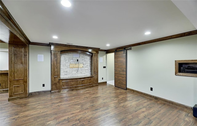 unfurnished room with recessed lighting, a barn door, crown molding, and wood finished floors