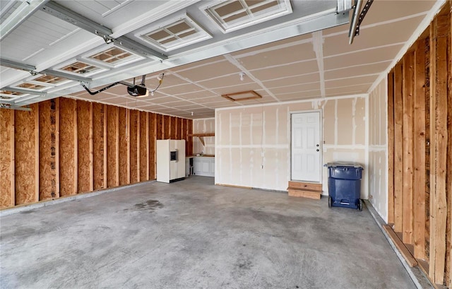 garage featuring a garage door opener and white refrigerator with ice dispenser