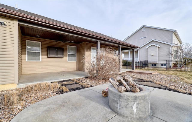 view of front of house featuring fence, a ceiling fan, and a patio