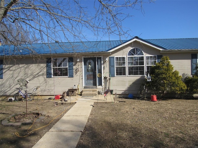 ranch-style home with entry steps and metal roof