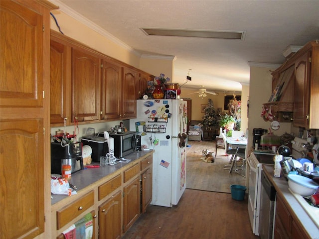 kitchen with dark wood-style floors, ornamental molding, freestanding refrigerator, and brown cabinets