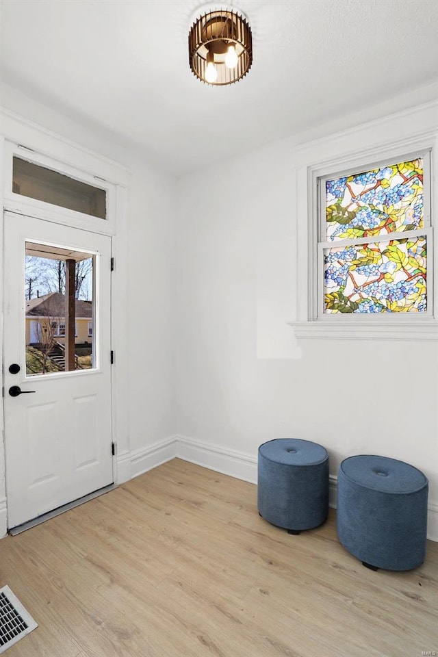 interior space featuring light wood-style flooring, visible vents, and baseboards