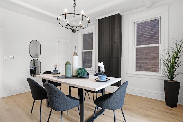 dining area featuring light wood-style floors, baseboards, ornamental molding, and a chandelier