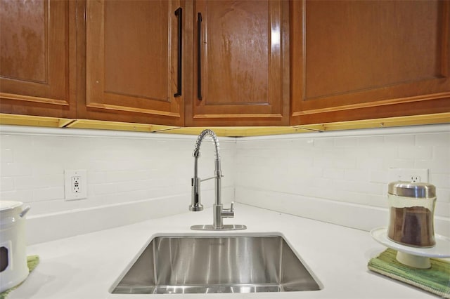 room details with light countertops, a sink, and decorative backsplash