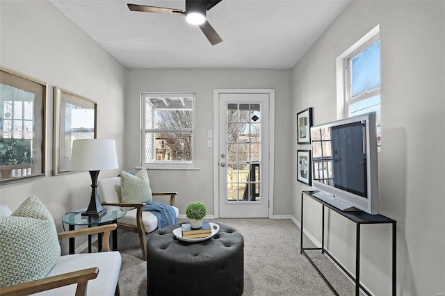 sitting room featuring baseboards, a textured ceiling, a ceiling fan, and carpet flooring