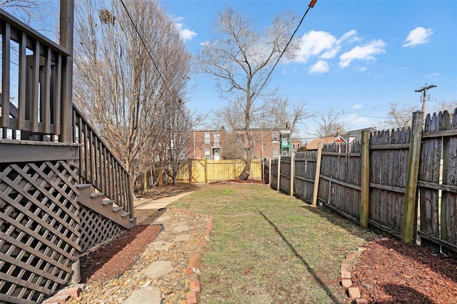 view of yard with a fenced backyard and stairs