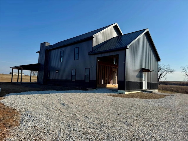 exterior space featuring metal roof and a chimney