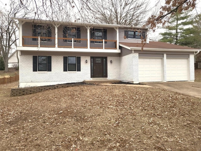 front facade featuring a balcony, a garage, concrete driveway, and brick siding