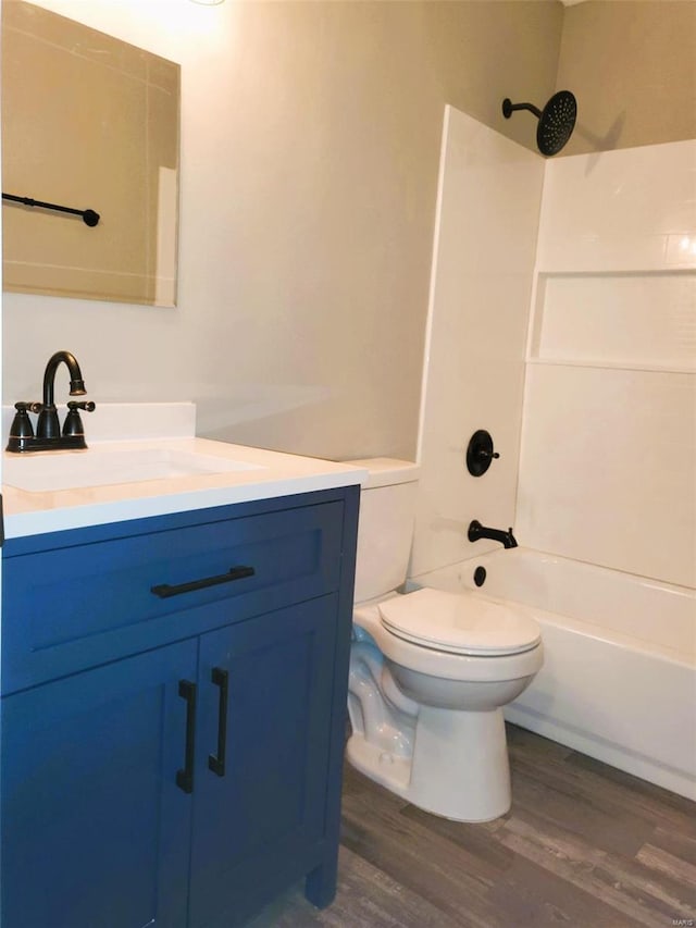 full bath with vanity, shower / bathing tub combination, wood finished floors, and toilet