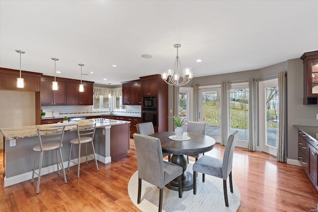 dining area featuring a chandelier, recessed lighting, light wood-style flooring, and baseboards