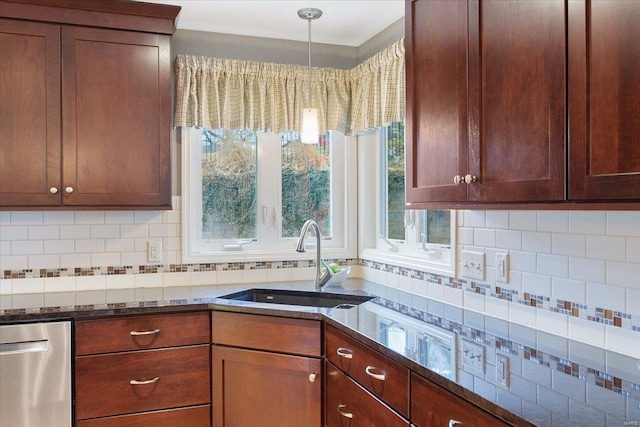 kitchen with tasteful backsplash, dark stone countertops, a sink, and stainless steel dishwasher