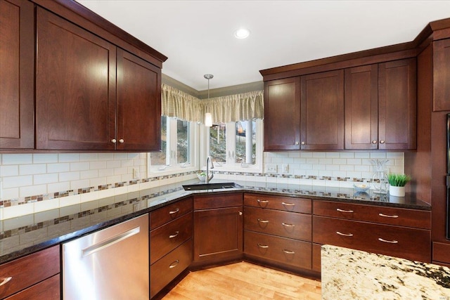 kitchen featuring dishwasher, dark stone counters, decorative backsplash, and light wood-style floors