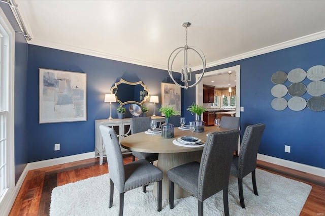 dining room with baseboards, wood finished floors, and a notable chandelier