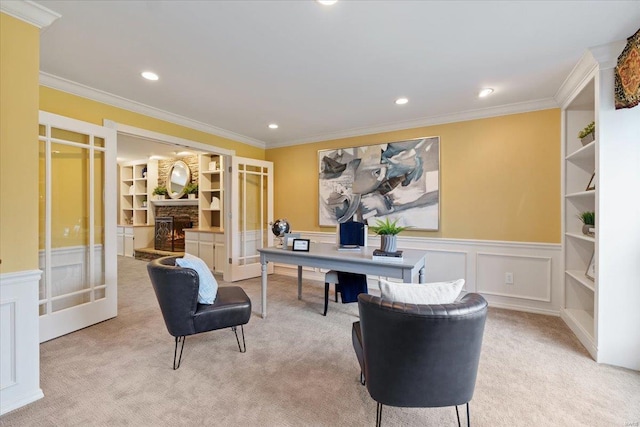 carpeted home office featuring built in shelves, ornamental molding, a stone fireplace, and french doors