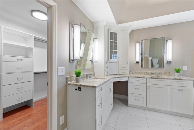 bathroom featuring marble finish floor, two vanities, and a sink