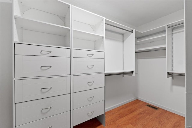 walk in closet with light wood finished floors and visible vents