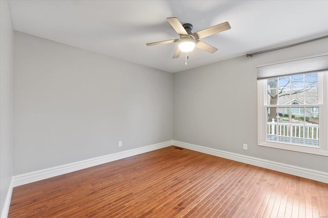 empty room with baseboards, ceiling fan, and hardwood / wood-style floors