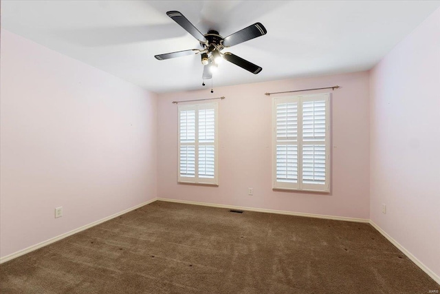 carpeted spare room with ceiling fan, visible vents, and baseboards