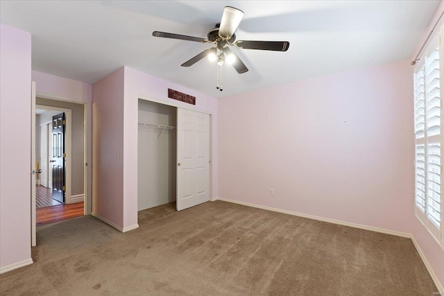 unfurnished bedroom featuring carpet, multiple windows, baseboards, and a closet