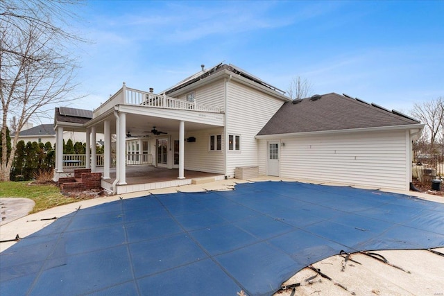 back of property with french doors, a patio area, ceiling fan, and solar panels