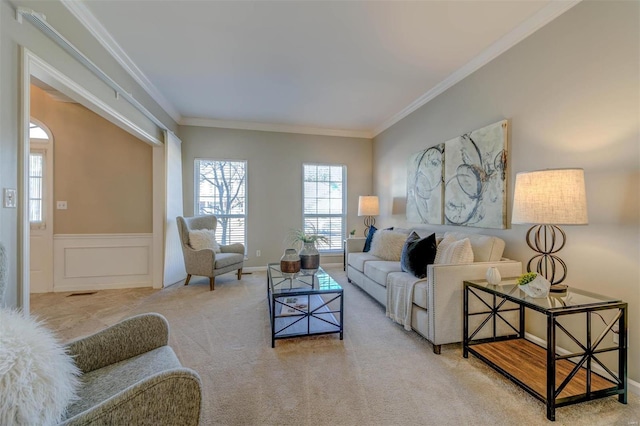 carpeted living room featuring a decorative wall, wainscoting, and crown molding