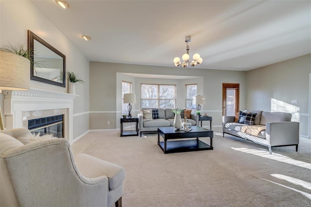 carpeted living room featuring a chandelier, a fireplace, and baseboards