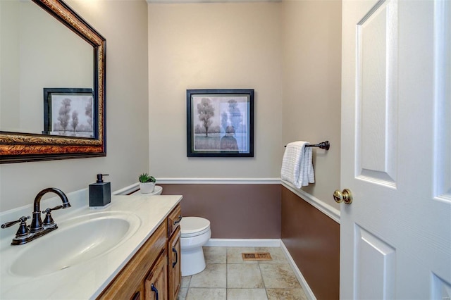 bathroom with baseboards, visible vents, toilet, tile patterned flooring, and vanity