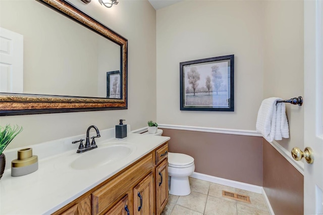 bathroom featuring visible vents, toilet, vanity, baseboards, and tile patterned floors