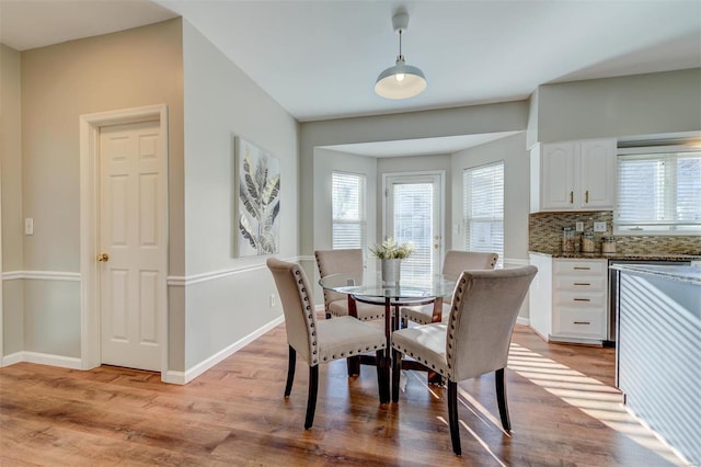 dining area featuring light wood-type flooring and baseboards