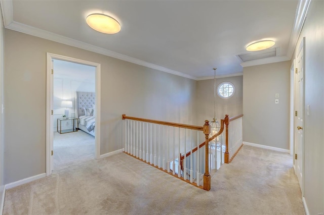 corridor with carpet flooring, crown molding, and an upstairs landing