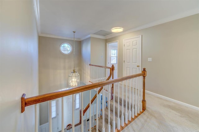 corridor with carpet floors, a notable chandelier, ornamental molding, an upstairs landing, and baseboards