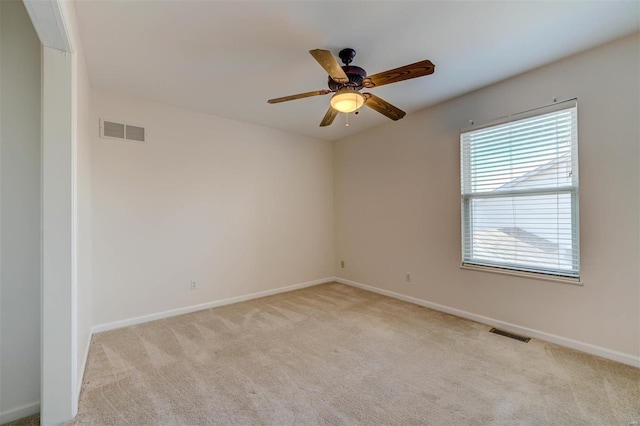 spare room with light carpet, baseboards, and visible vents