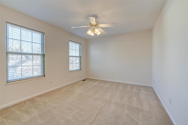 unfurnished room featuring light carpet, ceiling fan, and baseboards