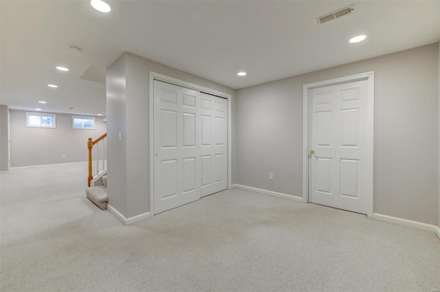 basement featuring carpet floors, stairway, and recessed lighting