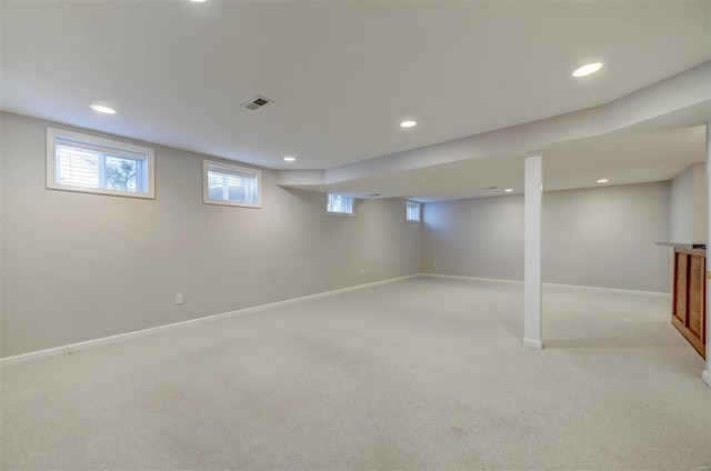 below grade area with light carpet, recessed lighting, visible vents, and baseboards