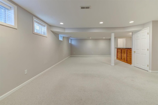 below grade area featuring light carpet, baseboards, visible vents, and recessed lighting