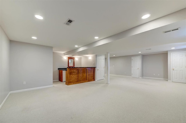 finished below grade area featuring recessed lighting, visible vents, and light carpet