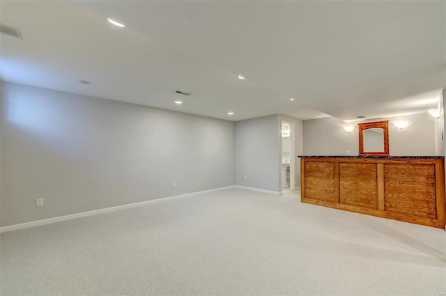 below grade area with light carpet, recessed lighting, visible vents, and baseboards