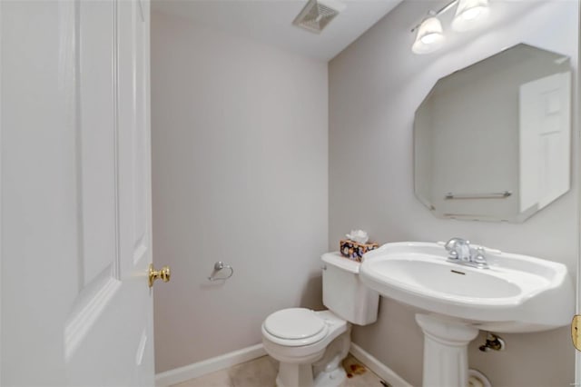 half bathroom featuring toilet, baseboards, visible vents, and tile patterned floors