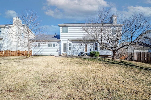 back of house with fence and a yard