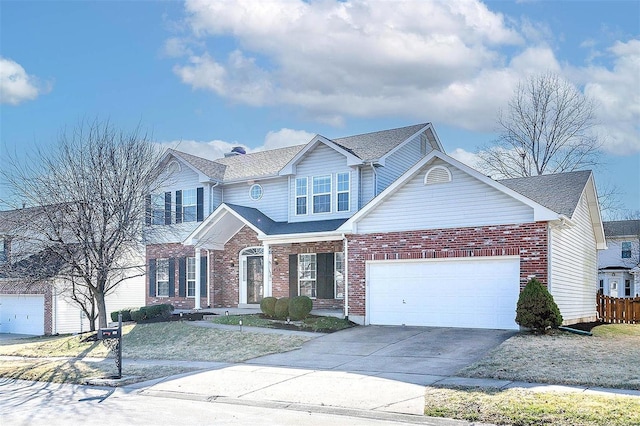 view of front of house with driveway, brick siding, an attached garage, and fence